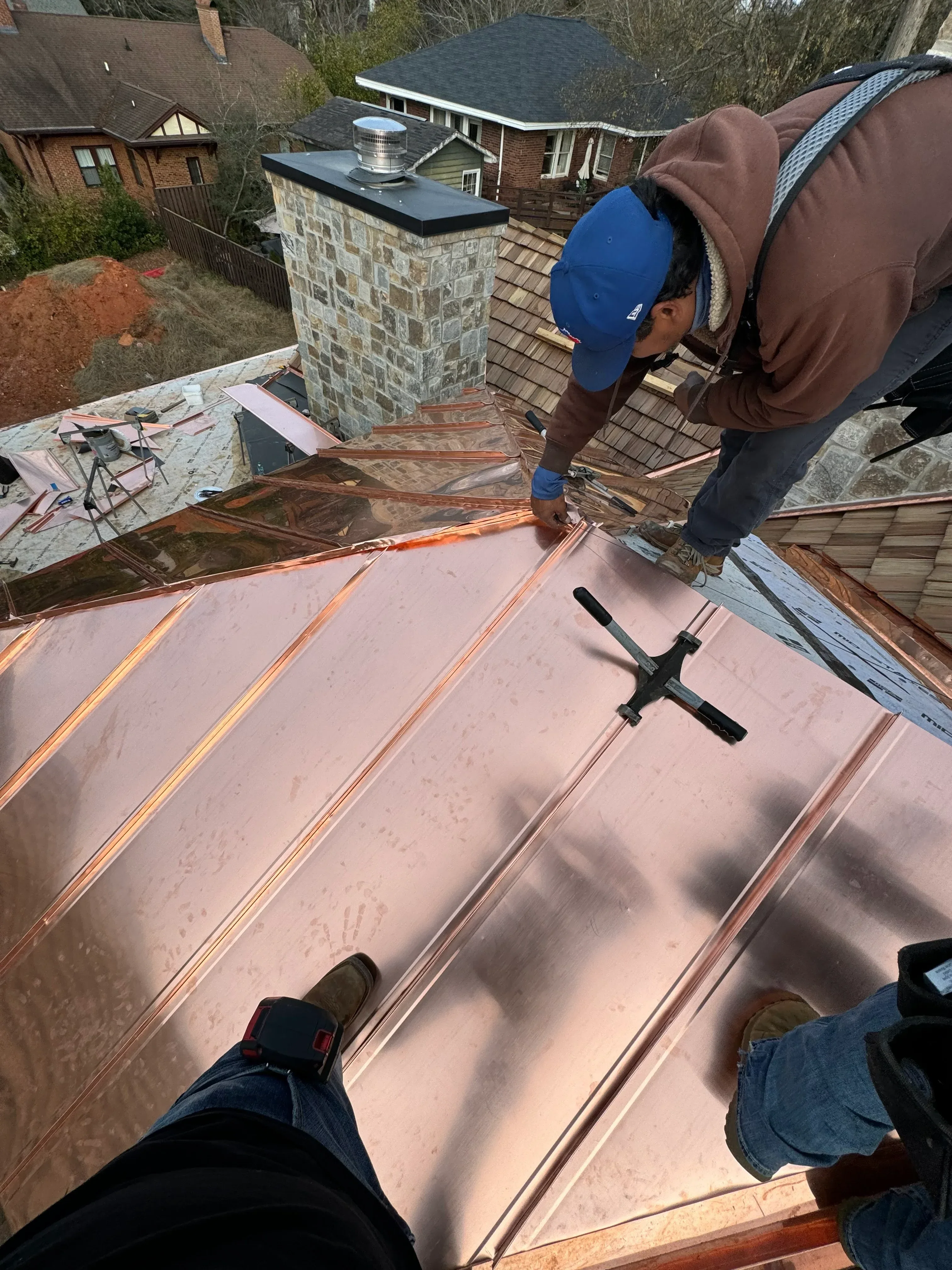 New asphalt shingle roof installation on residential home with copper flashing