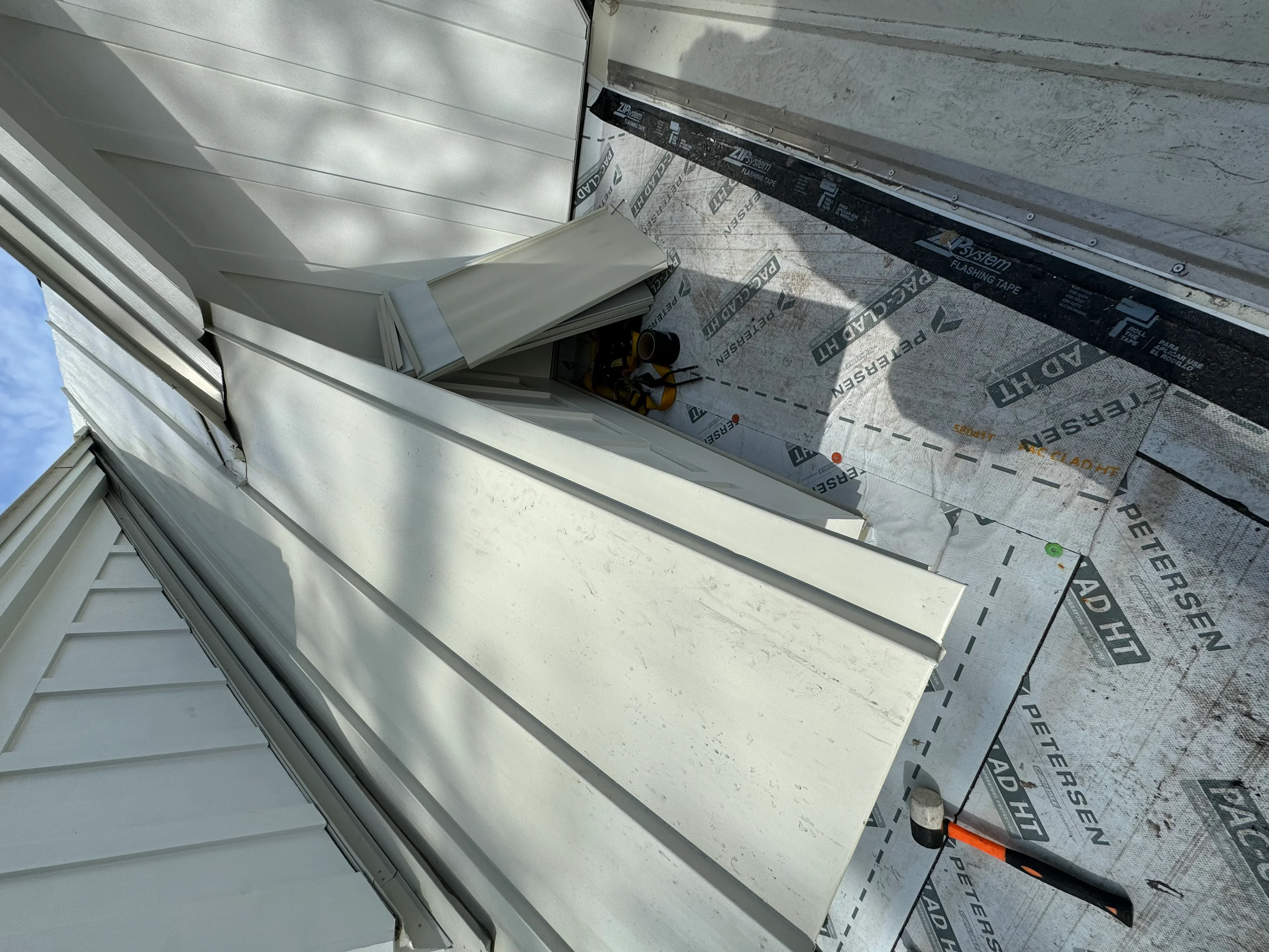 Roof decking with synthetic underlayment and ice and water shield installed during residential roofing project