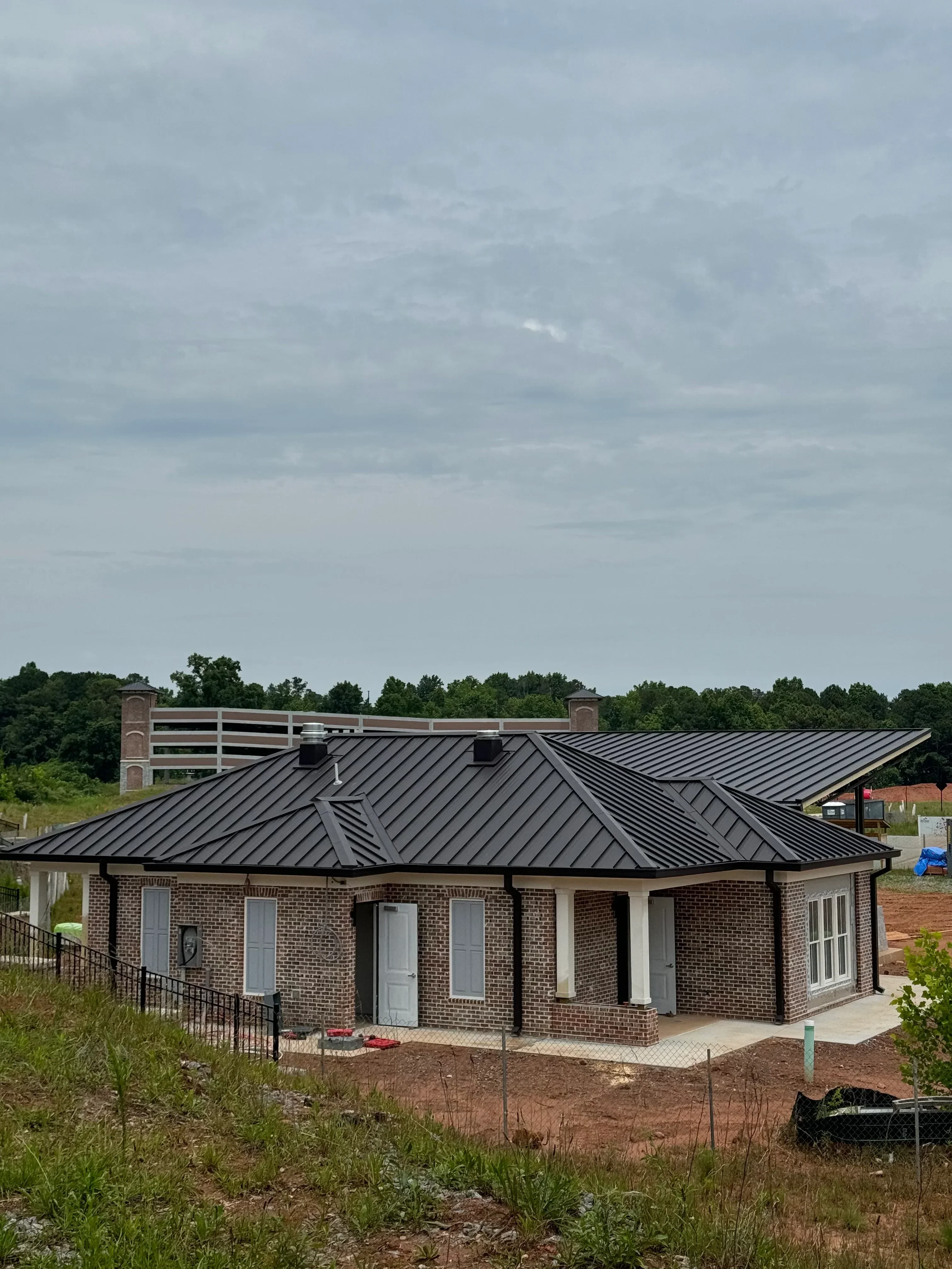 Standing seam metal roof installation on brick residential home with integrated flashing