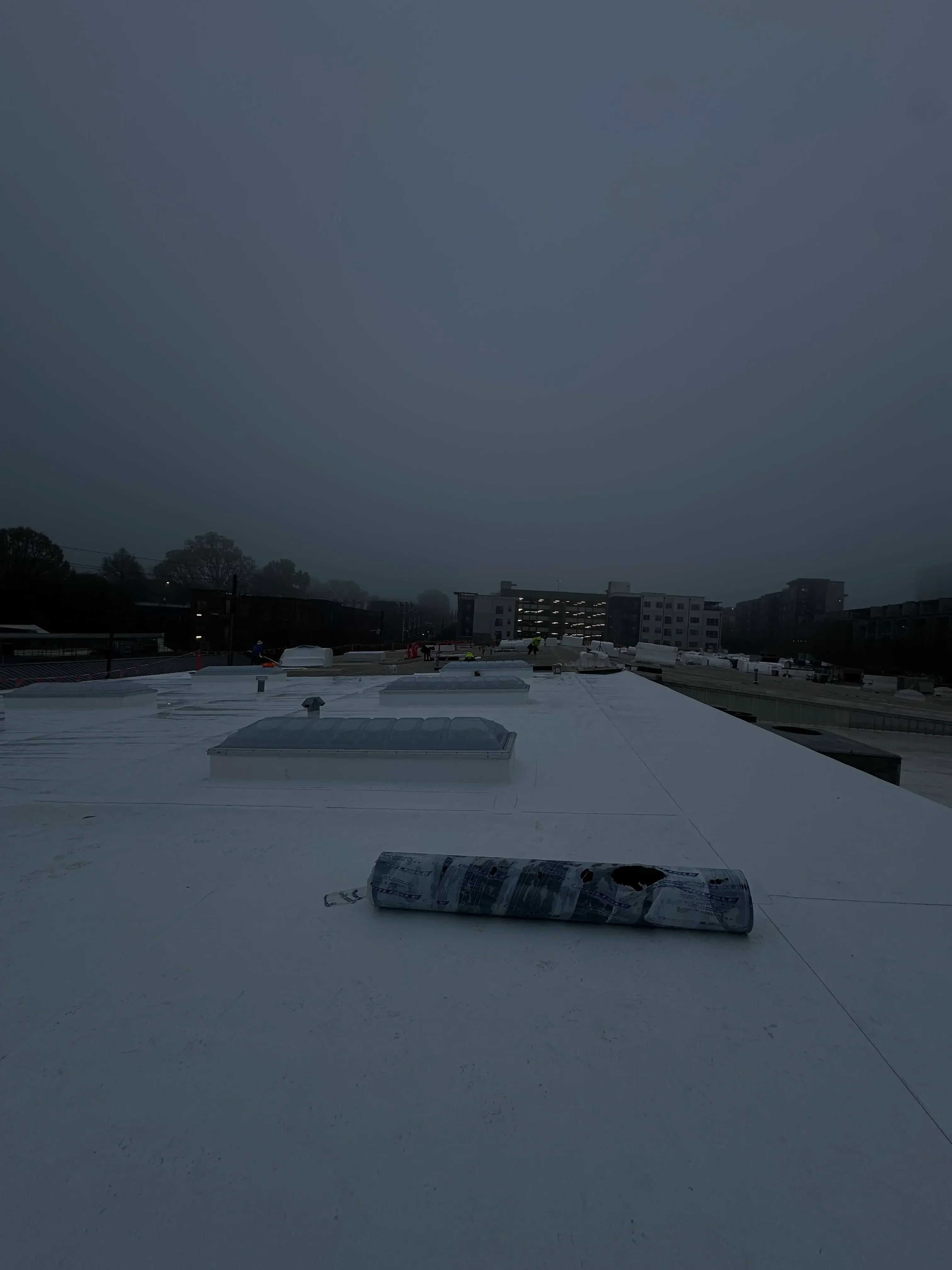 Standing seam metal roof installation on commercial building with flashing details